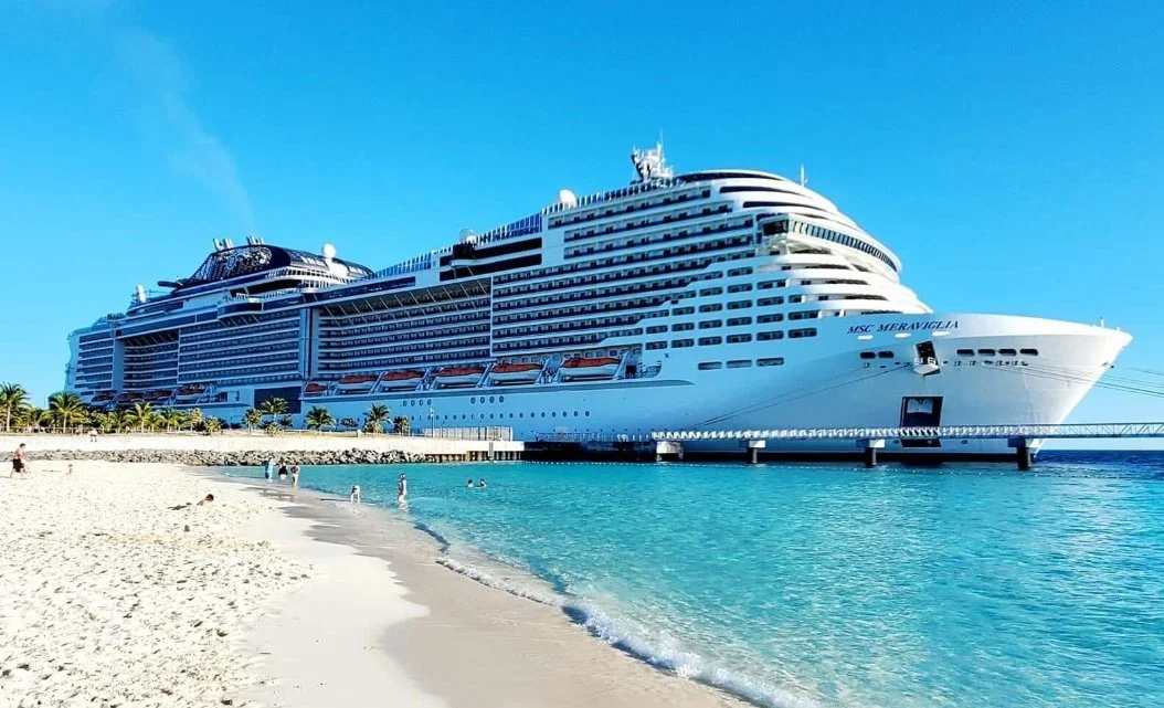 MSC Meraviglia docked beside a tropical beach during a family cruise with an older parent.