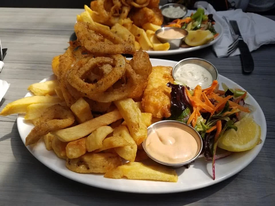 Fresh fried fish, calamari, chips, salad and dipping sauces served for lunch at The Fish Box in Dingle, Ireland.