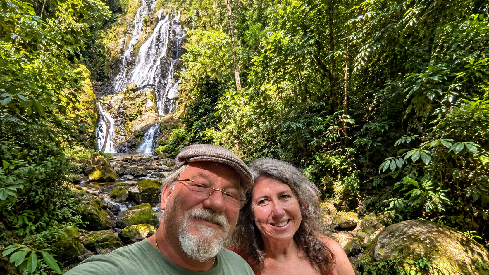 Two travelers stopping beside a waterfall while exploring the rural mountain roads around La Laguna and El Valle, Panama.