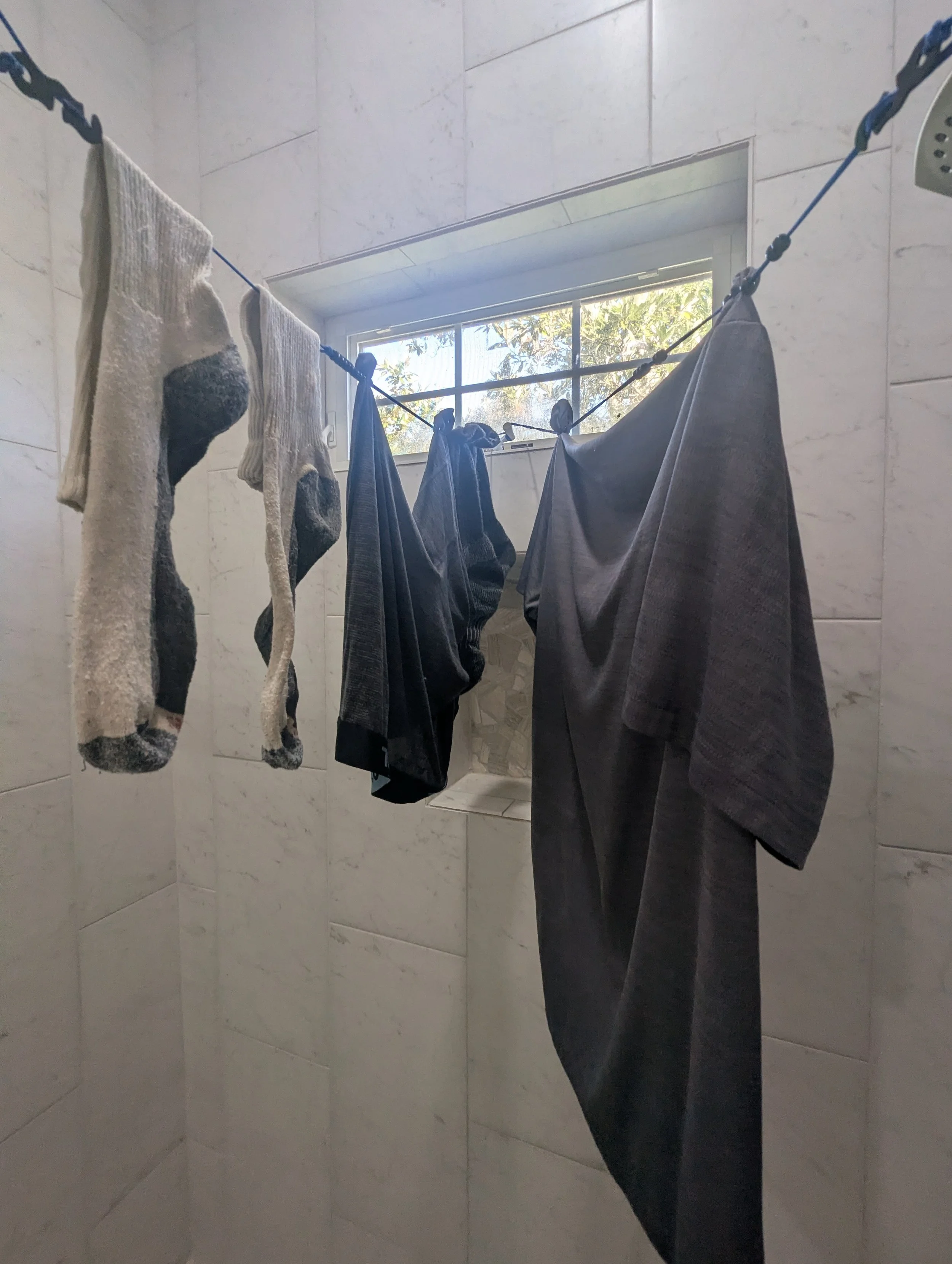 Socks and lightweight travel clothing held on portable clotheslines using sliding beads instead of clothespins.