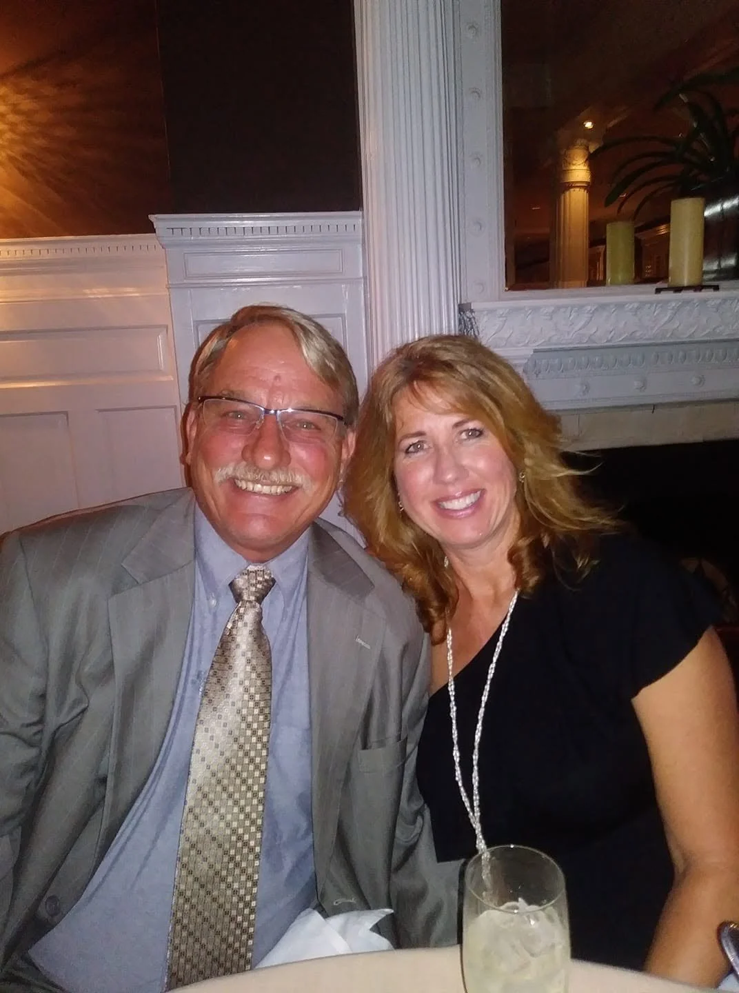Couple smiling together at their anniversary dinner inside the historic Jekyll Island Club Resort.