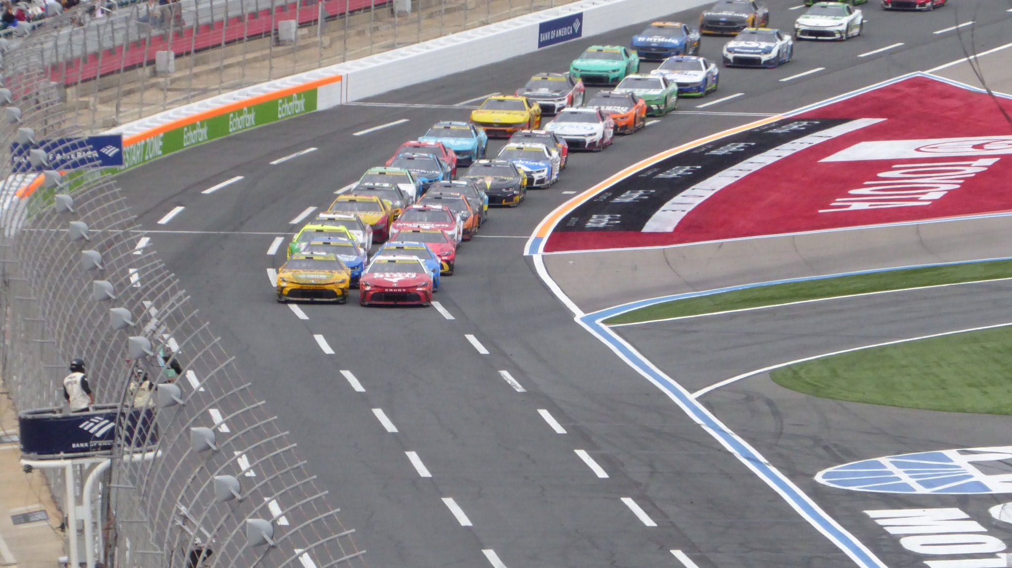 NASCAR Cup Series cars lined up across the frontstretch at Charlotte Motor Speedway before racing action.