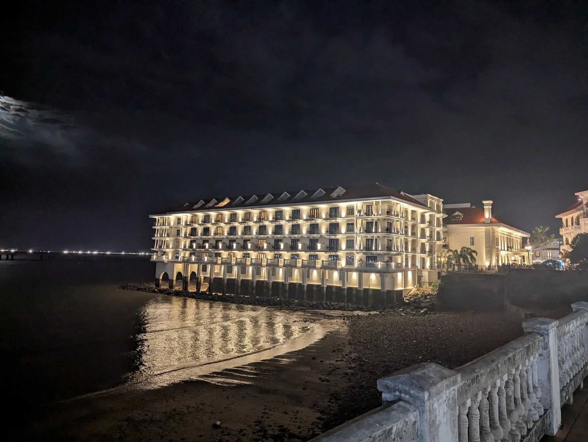Historic waterfront buildings glowing at night along the bay in Casco Viejo, Panama City.