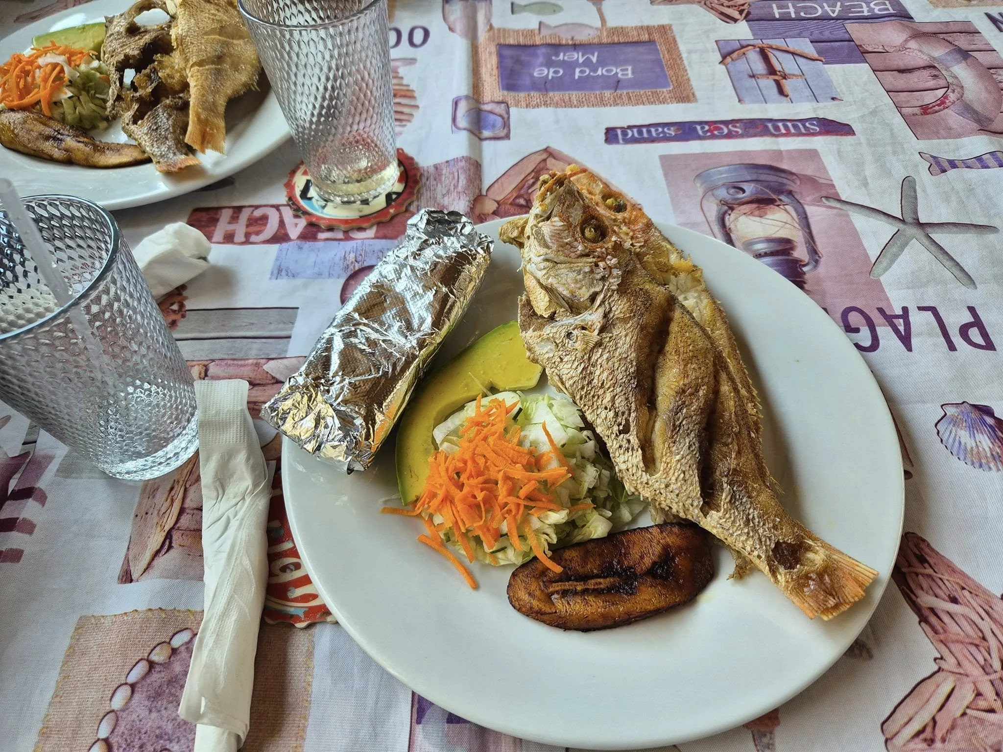 Freshly prepared whole fish with plantain and vegetables at a local waterfront restaurant in Curaçao.