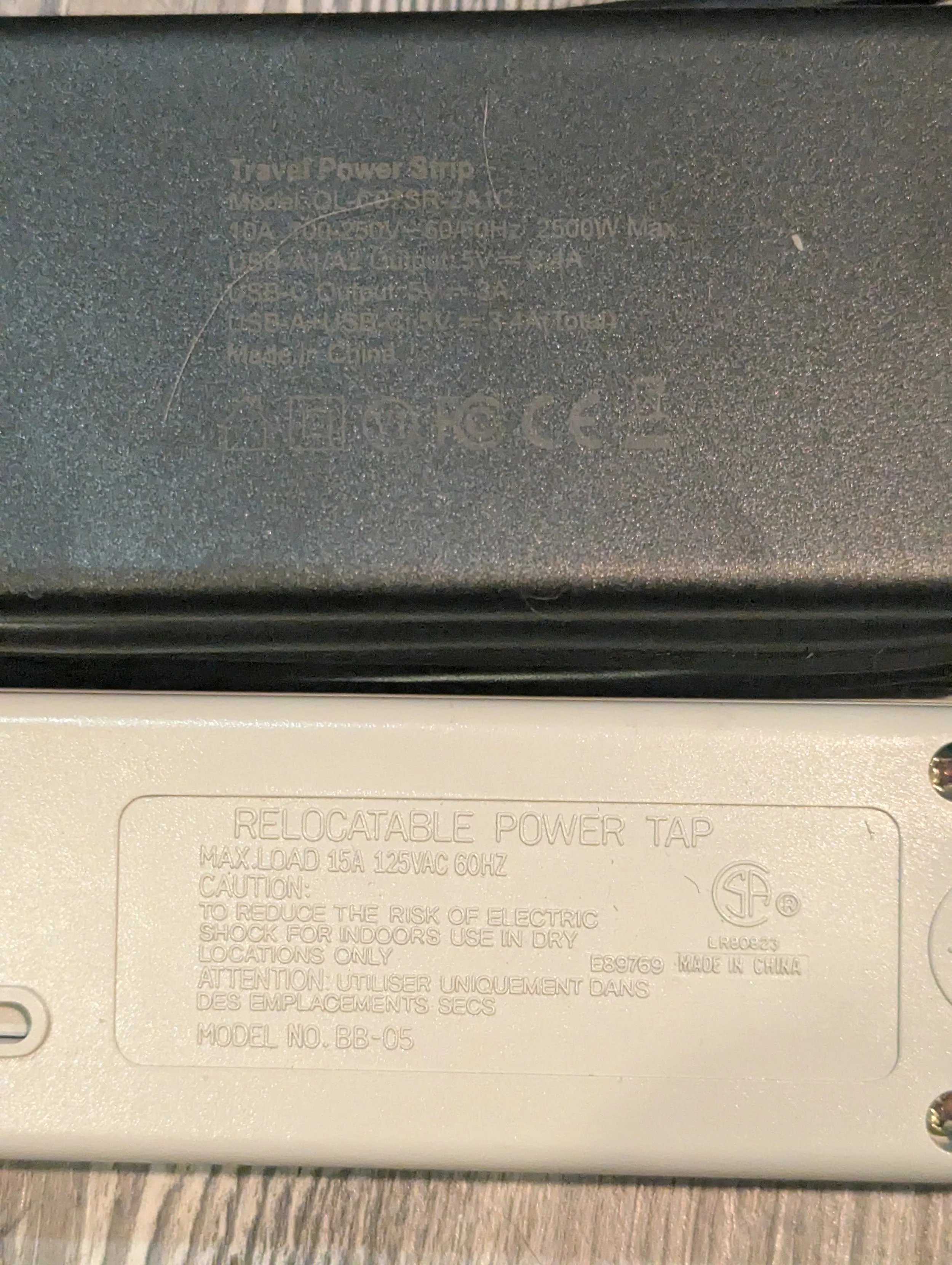 Electrical ratings comparing an older 125VAC U.S. power strip with an international travel power strip rated for 100–250V.
