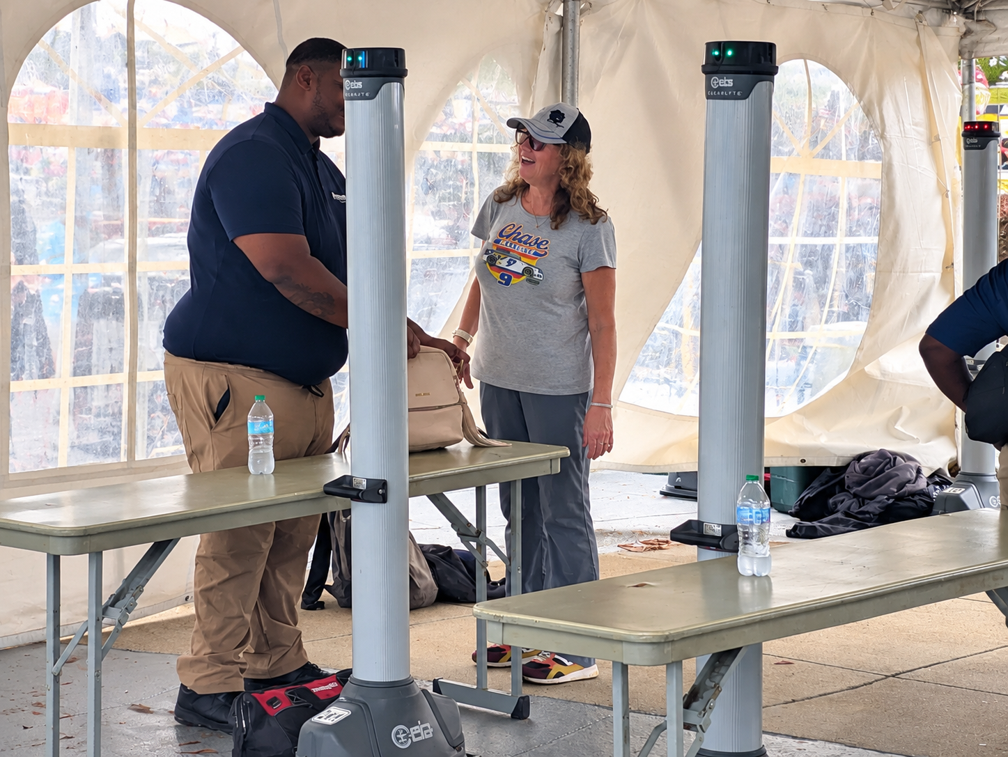 Visitor passing through walk-through security screening equipment at Charlotte Motor Speedway before entering the race venue.