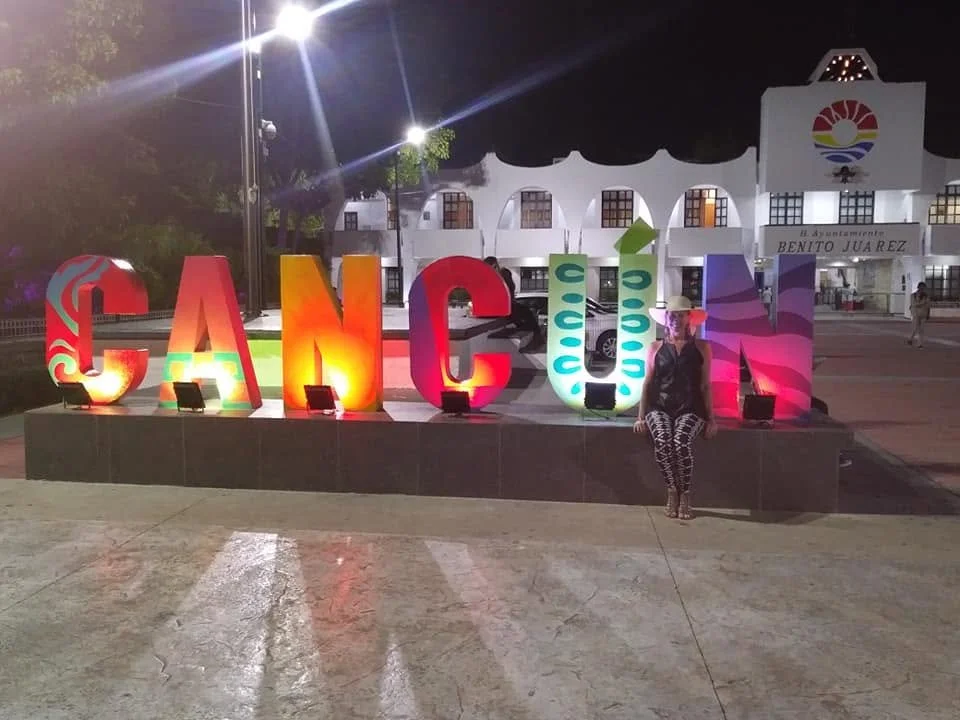illuminated cancun sign downtown in front of some shops