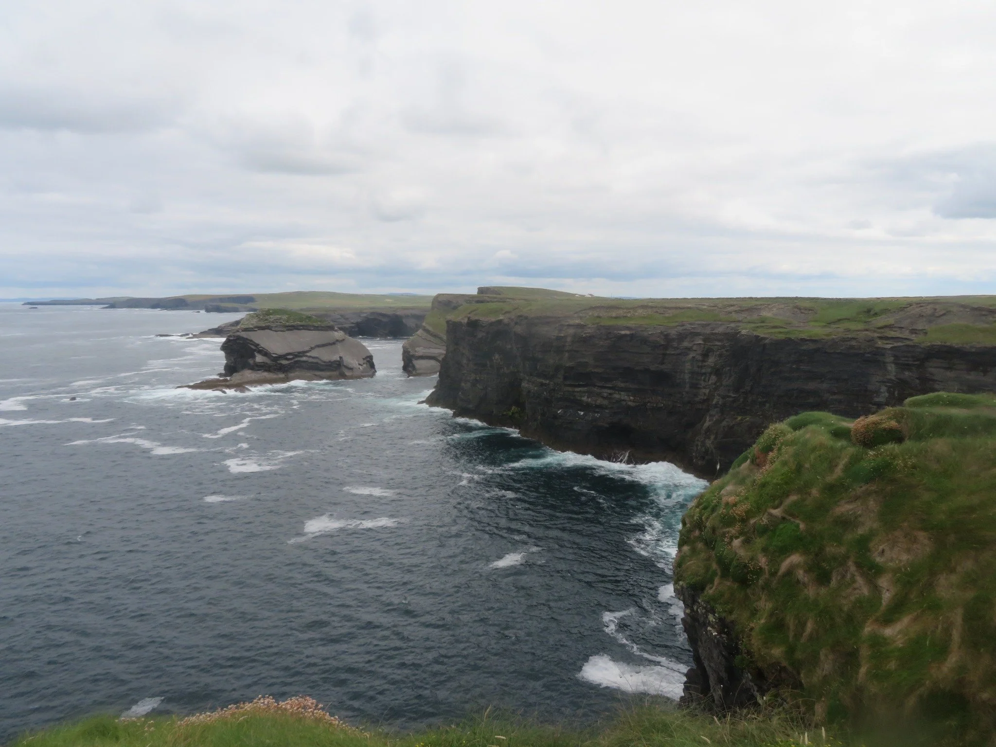 Deep ocean inlet and towering rock walls along the Kilkee Cliffs in County Clare, Ireland