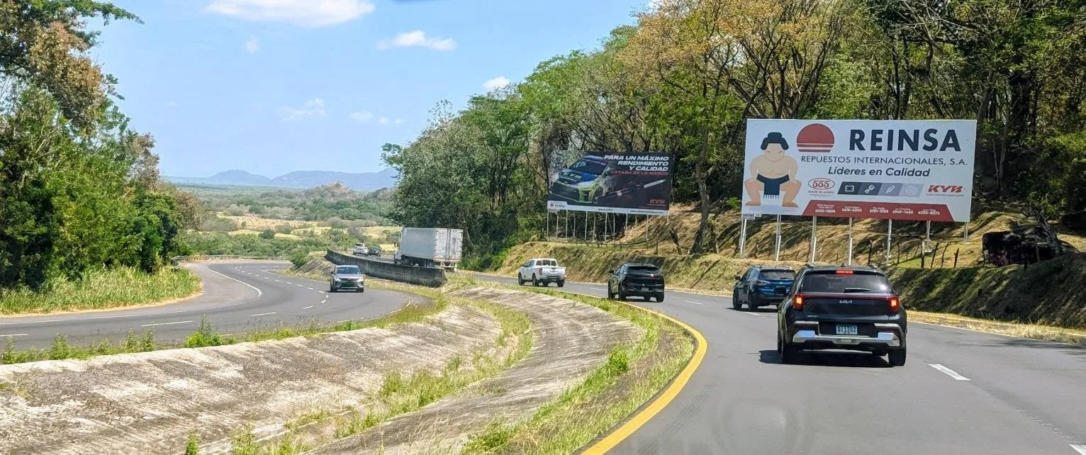 Driving west from Panama City on a modern highway with green mountains rising ahead.