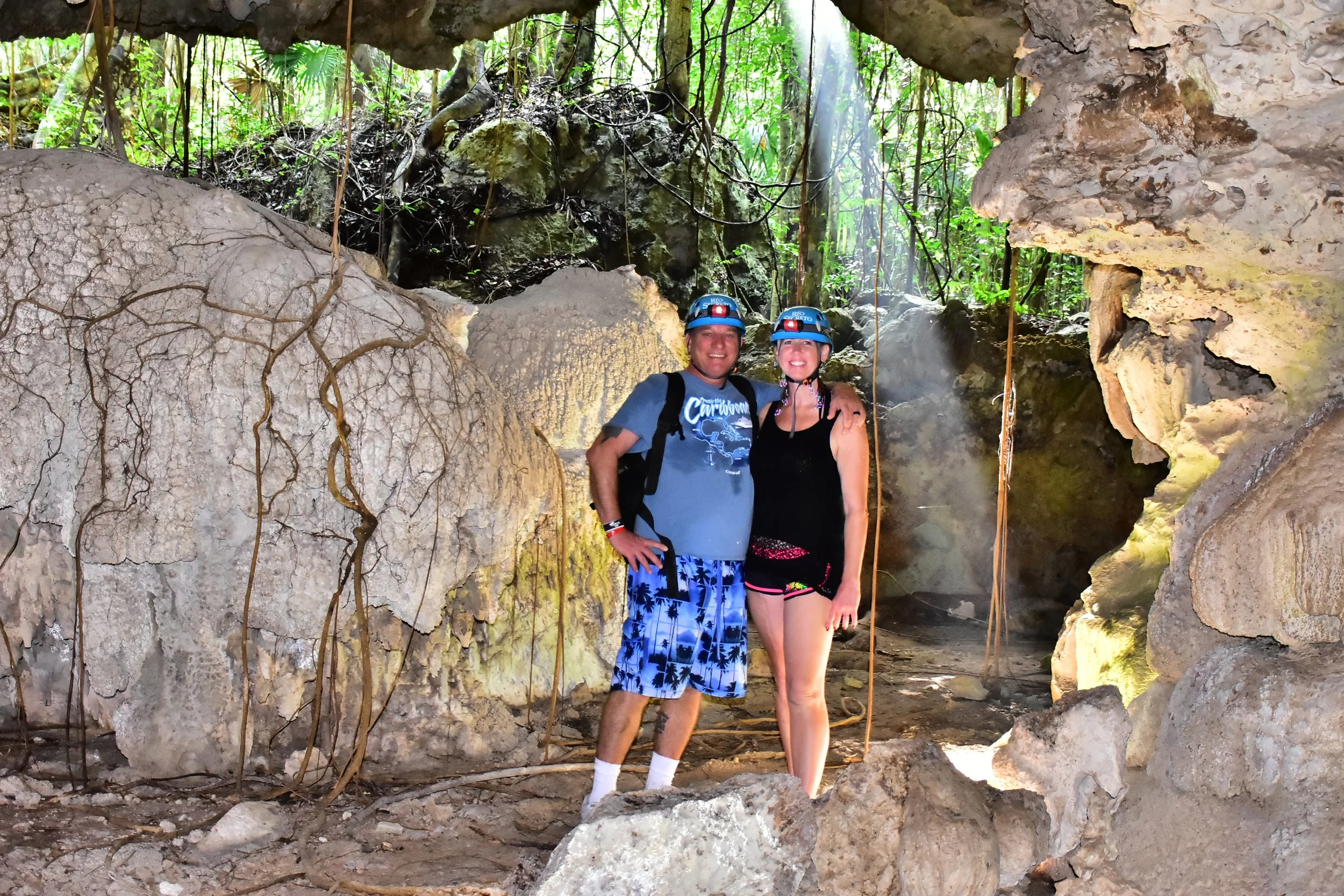 Brian and Gina walking through the jungle and into the underground water at Río Secreto during their Cancun honeymoon.
