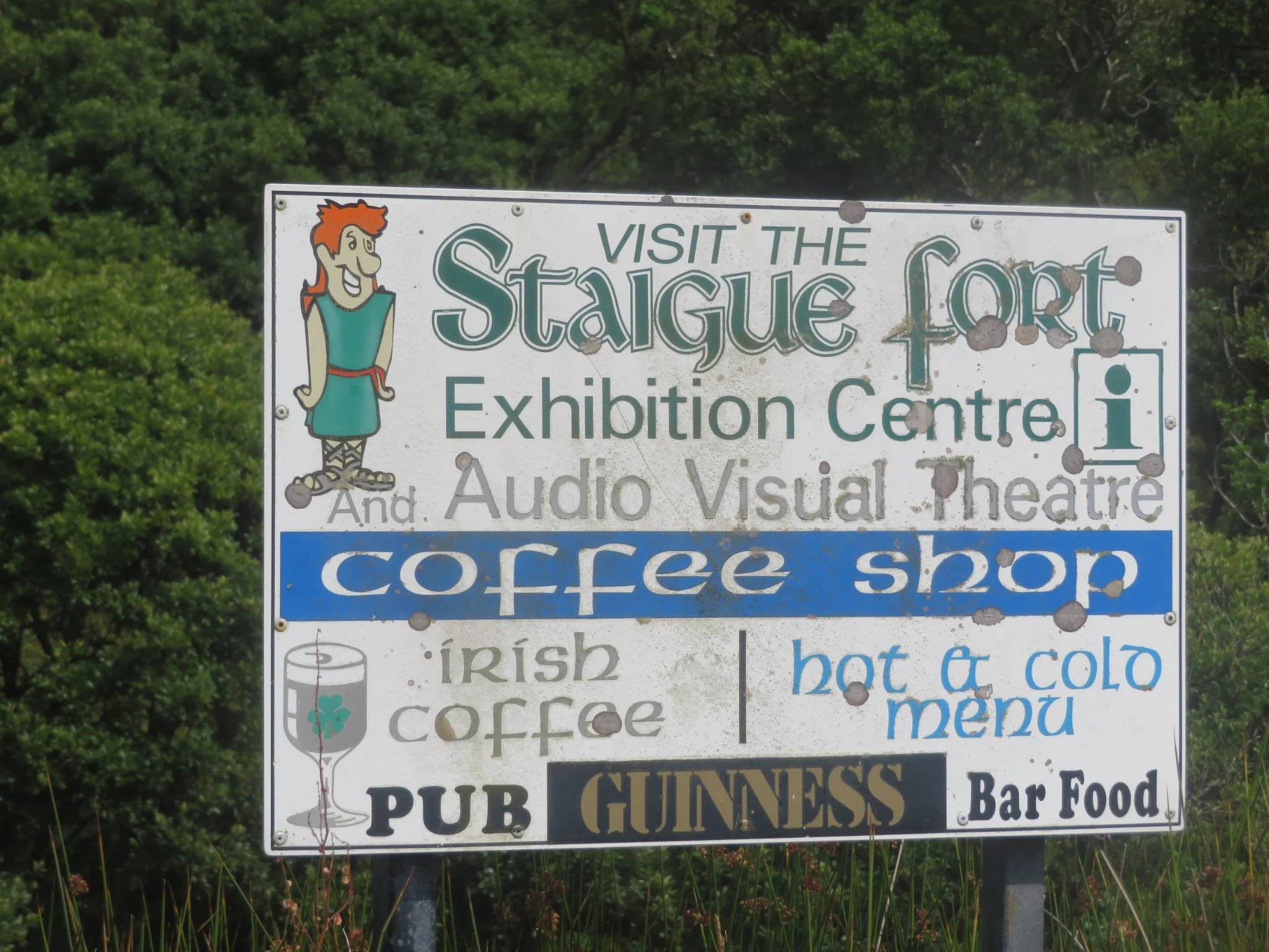 Weathered roadside sign pointing toward Staigue Fort during our self-drive trip through Ireland