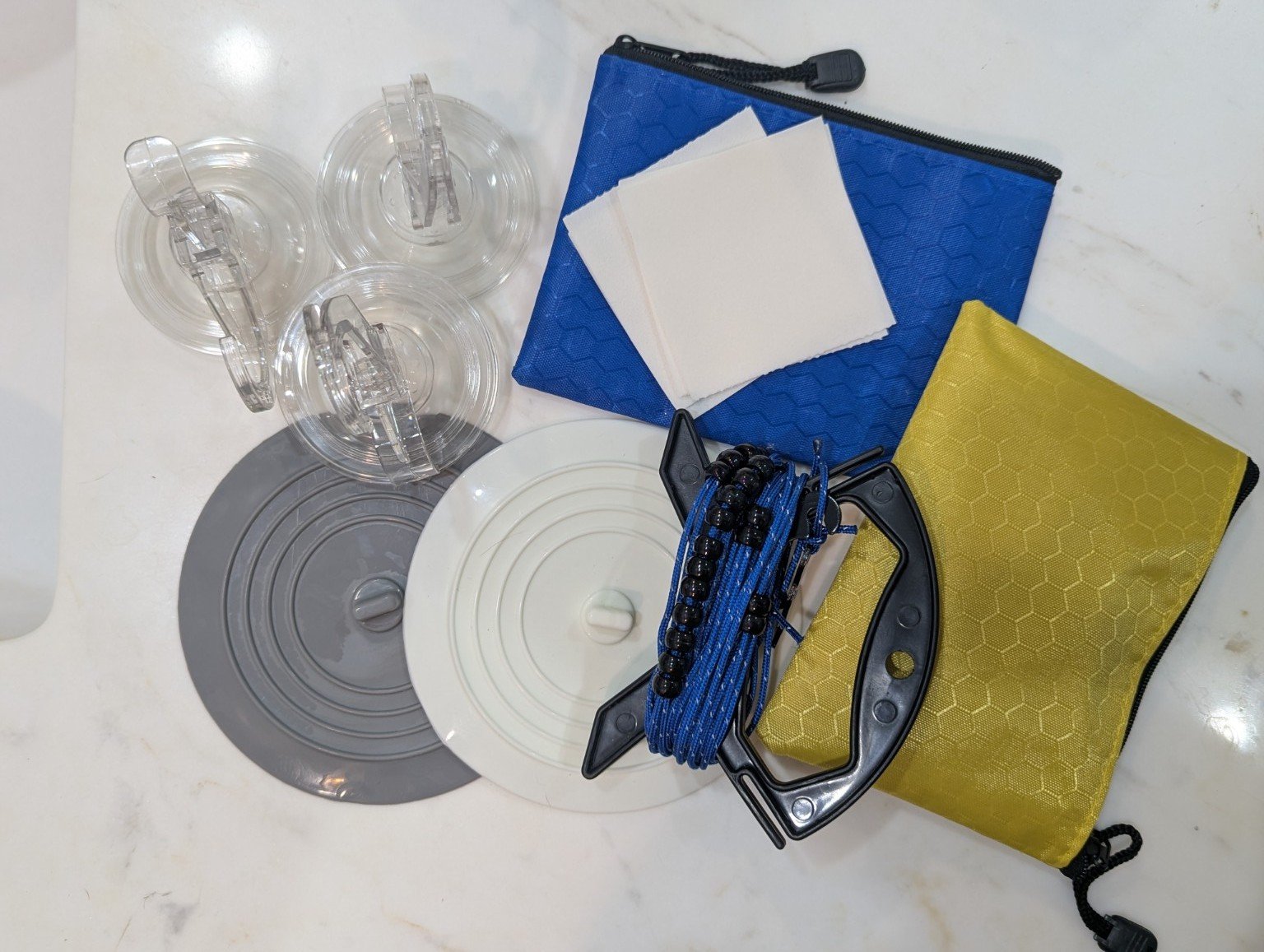 Complete travel laundry kit with two portable clotheslines, suction-cup hooks, silicone sink stoppers and laundry detergent sheets.