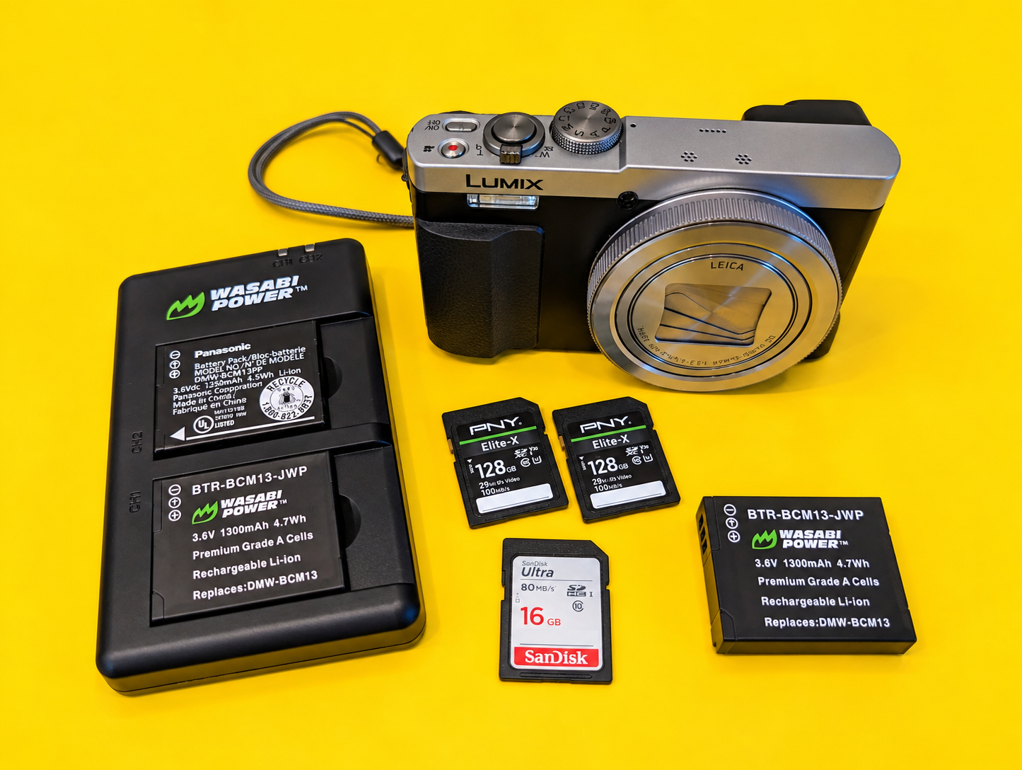 Panasonic Lumix ZS50 compact travel camera and accessories photographed against a bright yellow background for a real-world travel photography review.