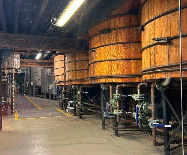 Large wooden vats inside Kilbeggan Distillery during our whiskey experience in Ireland.