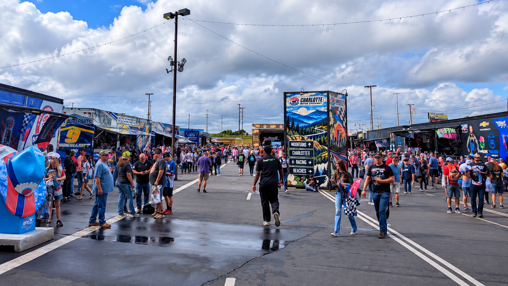 NASCAR fans exploring merchandise haulers and activities in the Fan Zone at Charlotte Motor Speedway.