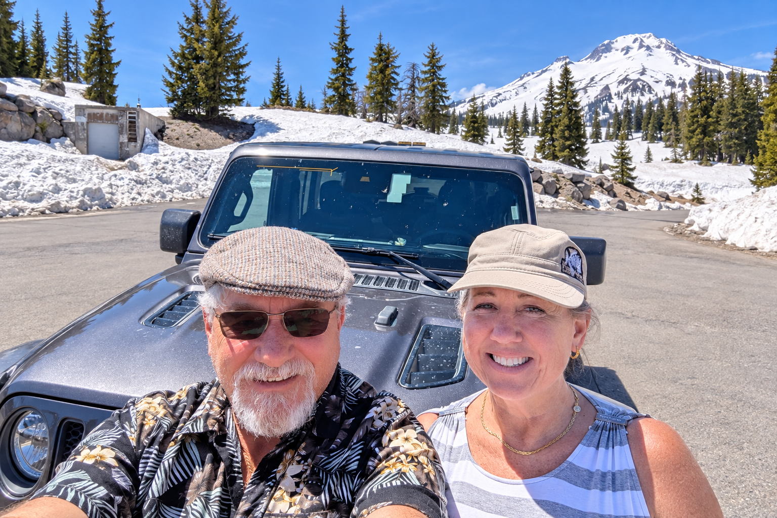 Brian and Gina smiling in front of their Jeep rental near deep snow in Oregon