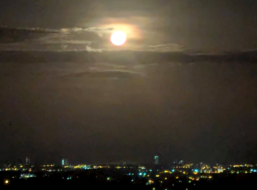 Full moon shining above the distant lights of Panama’s Pacific coast, viewed at night from Hawk’s Nest in La Laguna.