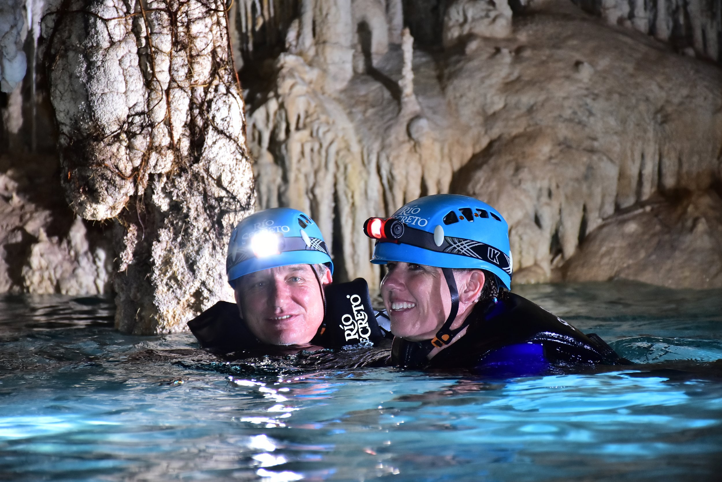 Brian and Gina snorkeling through a cenote cavern in rio secreto