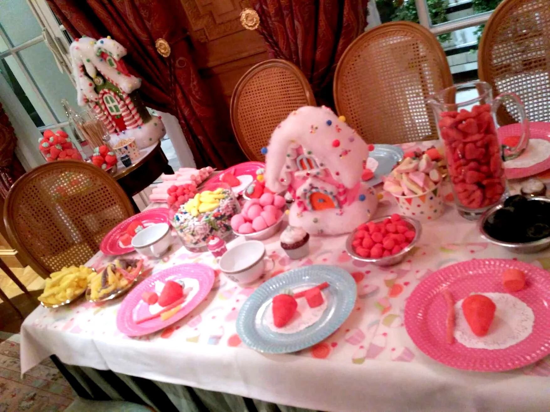 Table décorée pour une fête de Noël avec des bonbons, gâteaux, fruits, et décorations de Noël