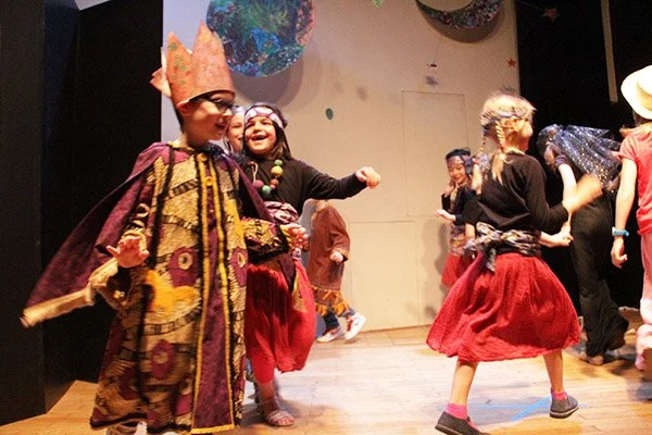 Enfants en costume de carnaval dans une pièce de théâtre ou une fête.