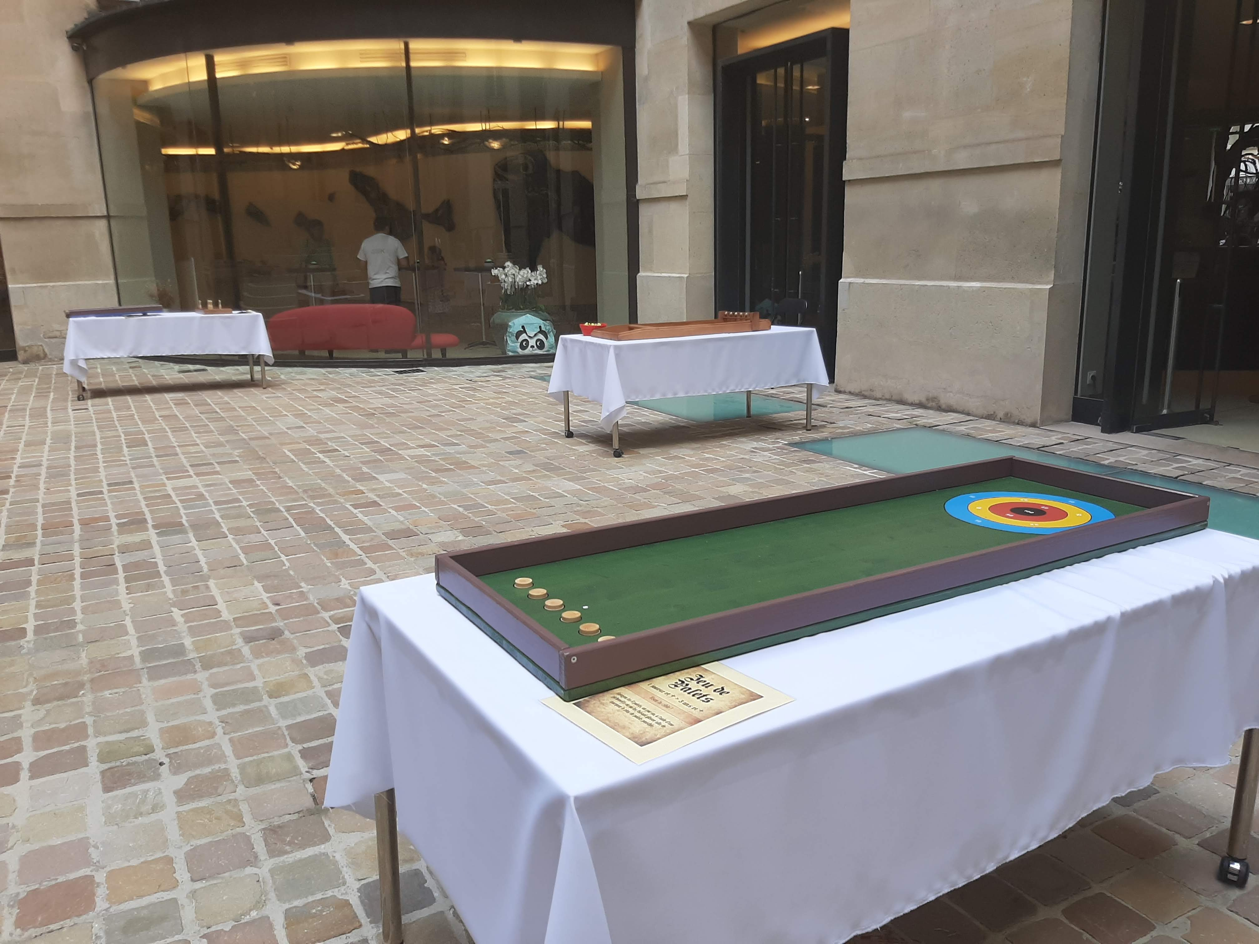 Table avec des pièces de jeu de croquet et une affiche intitulée 'Jeu de Croquet'.