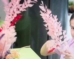 Fille tenant une branche de plante décorative pastel