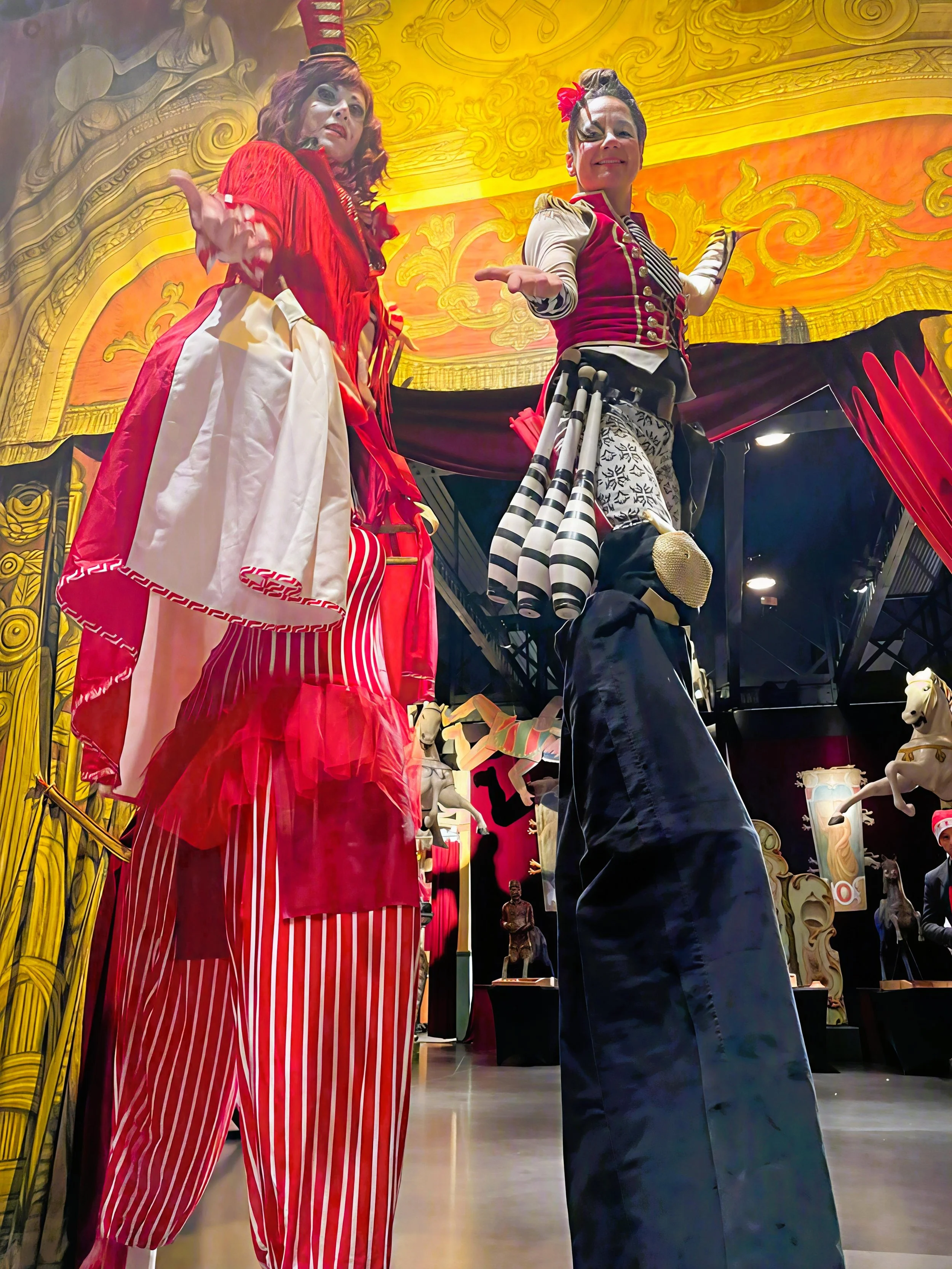 Un homme en costume avec un chapeau de Père Noël prépare des bonbons ou des friandises dans un chariot de fête foraine ou de marché de Noël à l'extérieur, avec des boissons en sachets derrière lui.