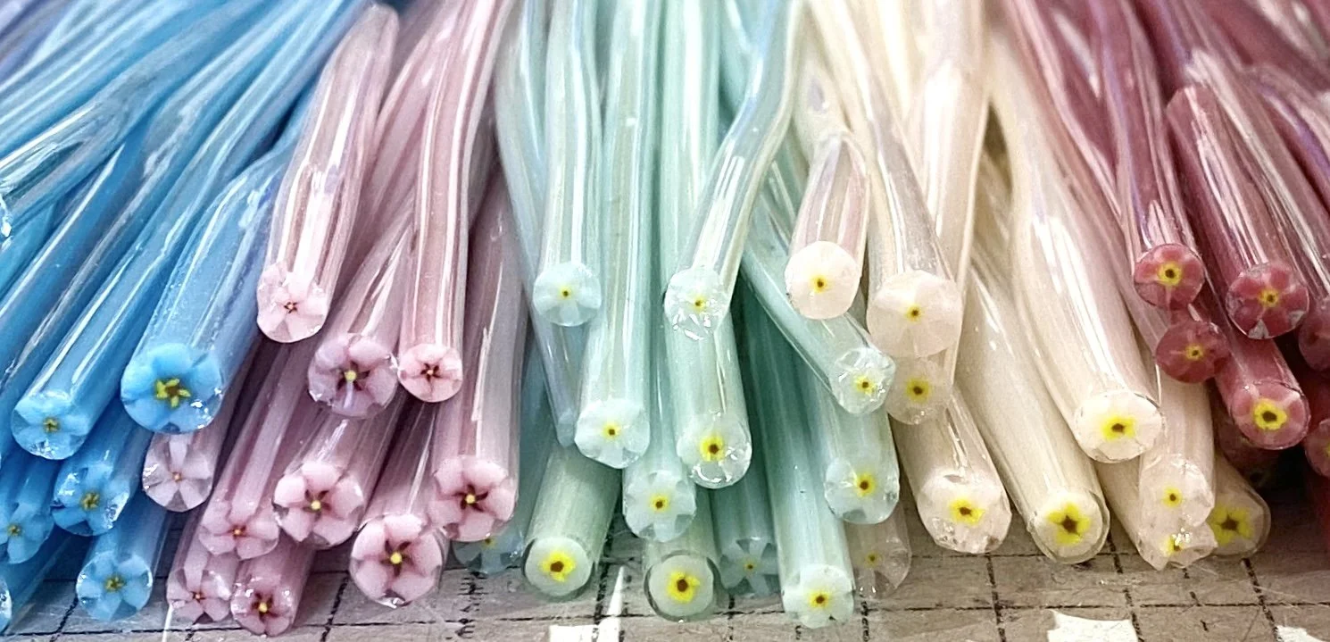 Colourful glass murrini canes in assorted colours including pink, blue, green, yellow, orange and red.