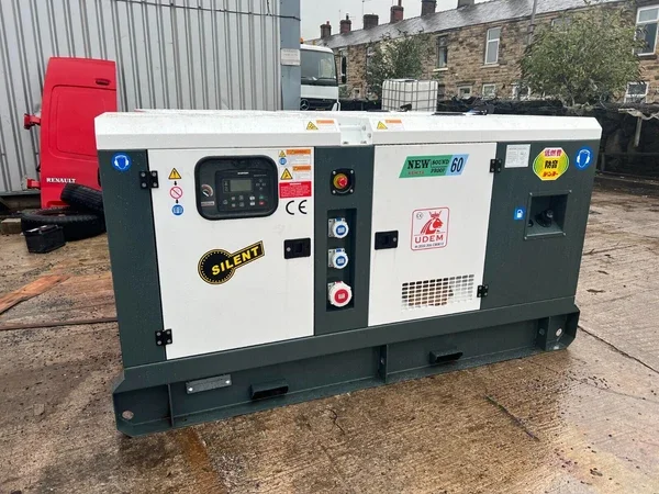 Large industrial generator with control panel, stickers, and warning labels, situated outdoors on a concrete surface.