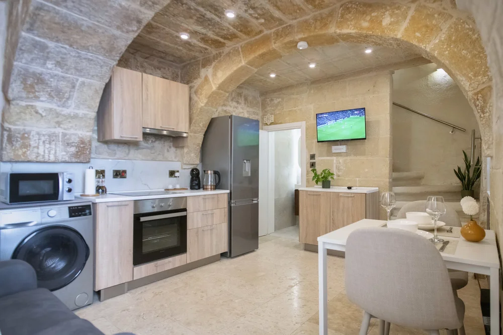 Kitchen, dining table and staircase at Hnejja Stays, Floriana, Malta
