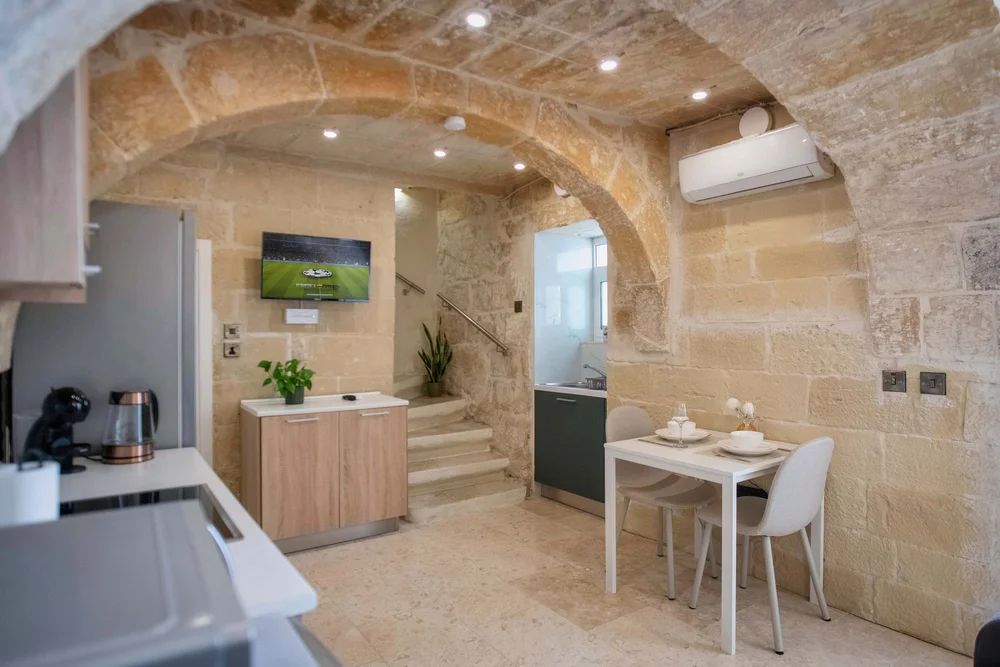 Kitchenette and dining nook under a vaulted stone ceiling, Hnejja Stays maisonette, Floriana, Malta