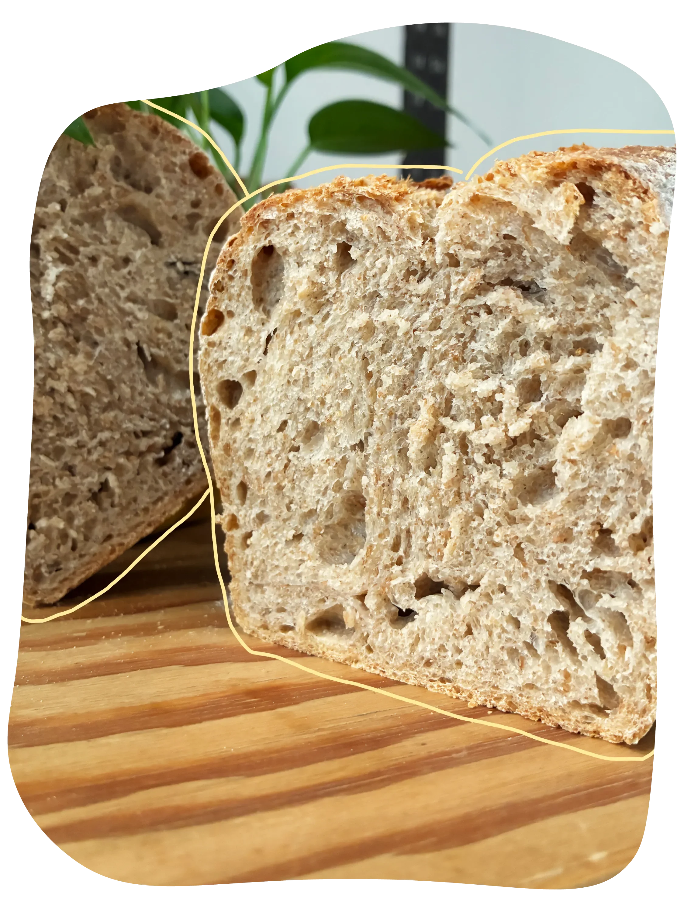 Pan de masa madre cortado en rebanadas, colocado sobre una tabla de madera con rayas oscuras.