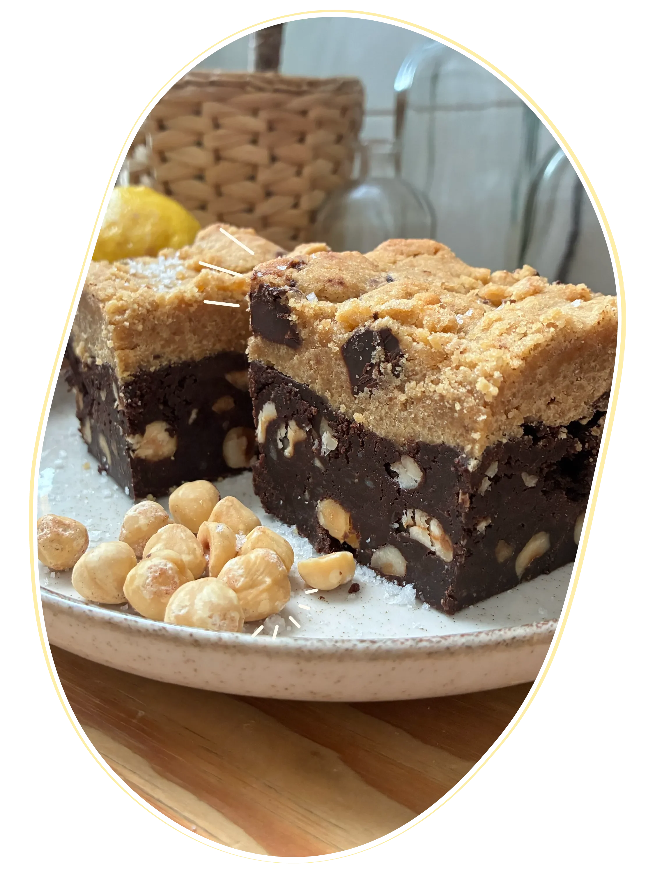Brookie de chocolate con avellanas y galleta en un plato, acompañado de avellanas, en un ambiente interior con cestas de madera y un jarrón de vidrio en el fondo.