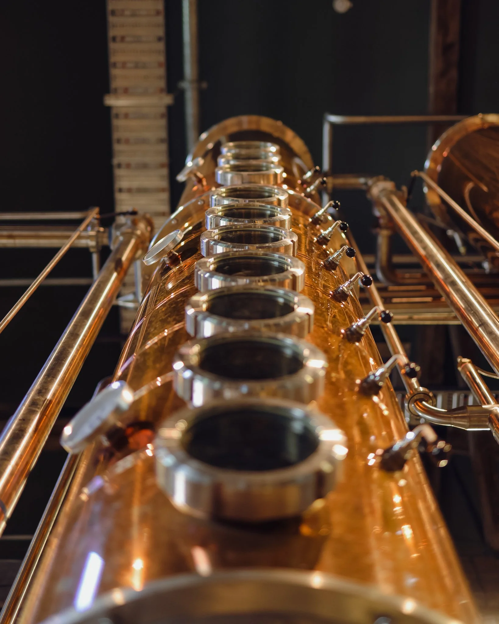 Close-up of a copper tube or pipe with multiple rings or sections, part of a mechanical or industrial setup.