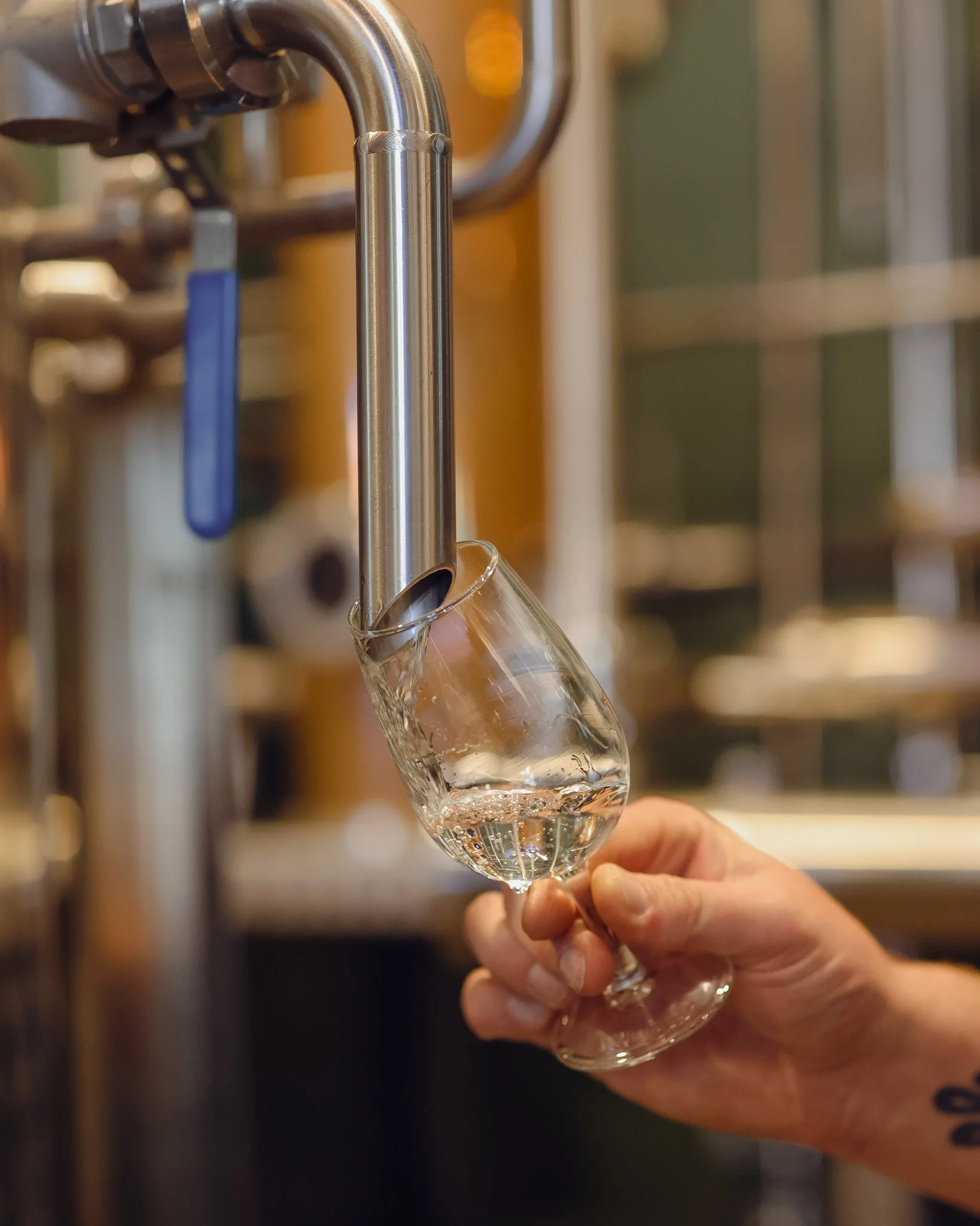 Person filling a glass with water from a tap.