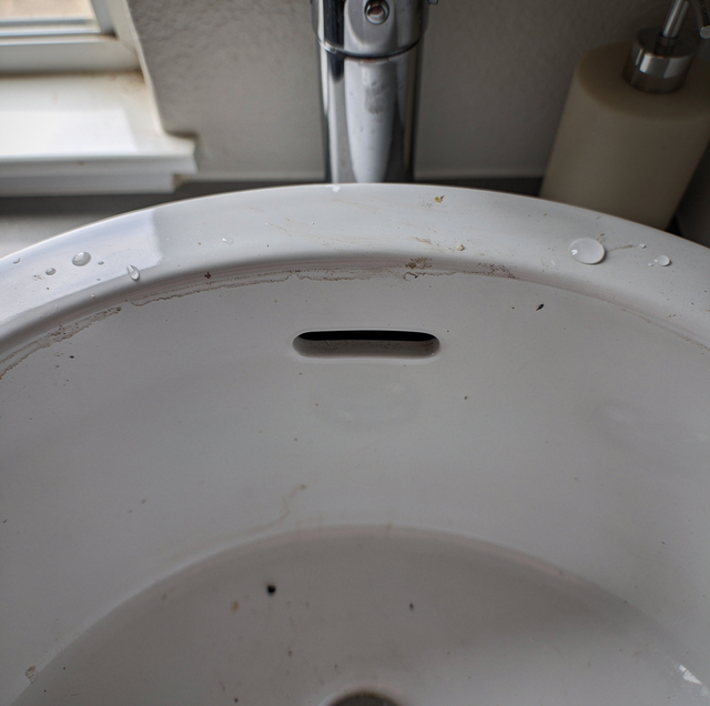 bathroom sink overflow cavity with grimy rim slot