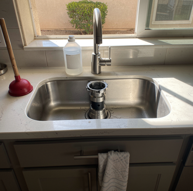 kitchen sink overflow with plunger and drain cleaner bottle