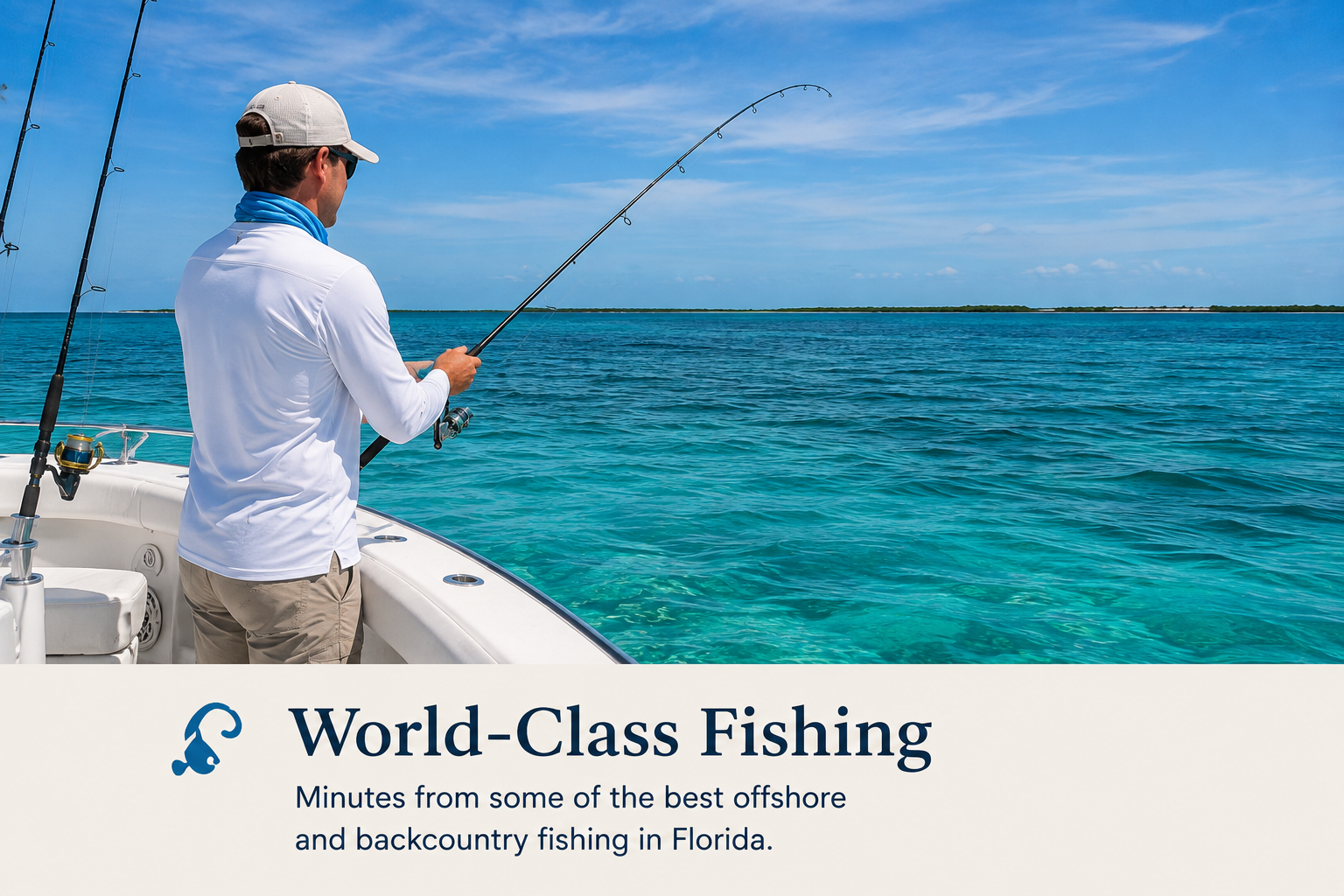 A man fishing on a boat in clear blue water under a sunny sky, with a low-lying island in the distance.