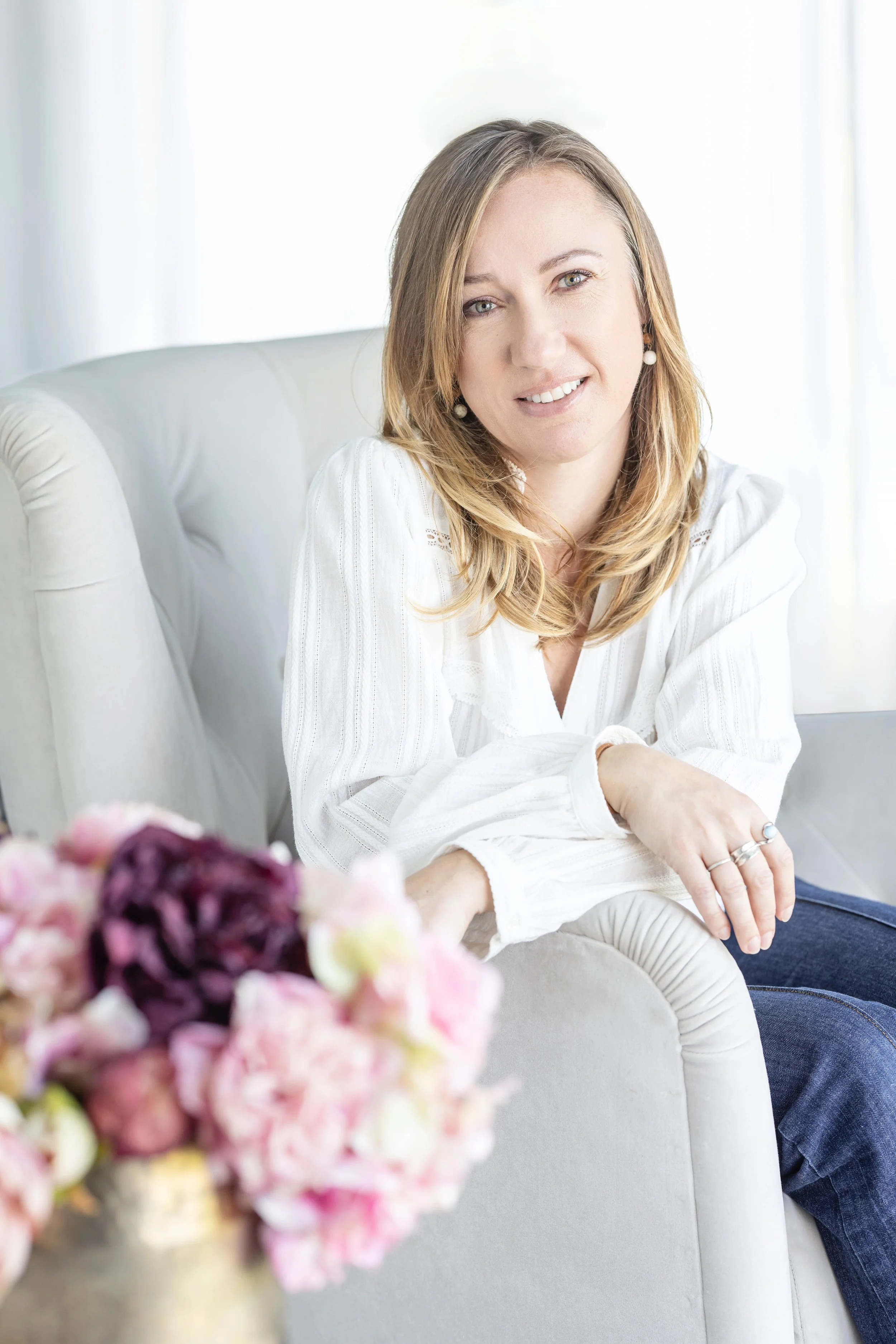 Amandine Charton, architecte d'intérieur, souriante avec un bouquet de fleurs