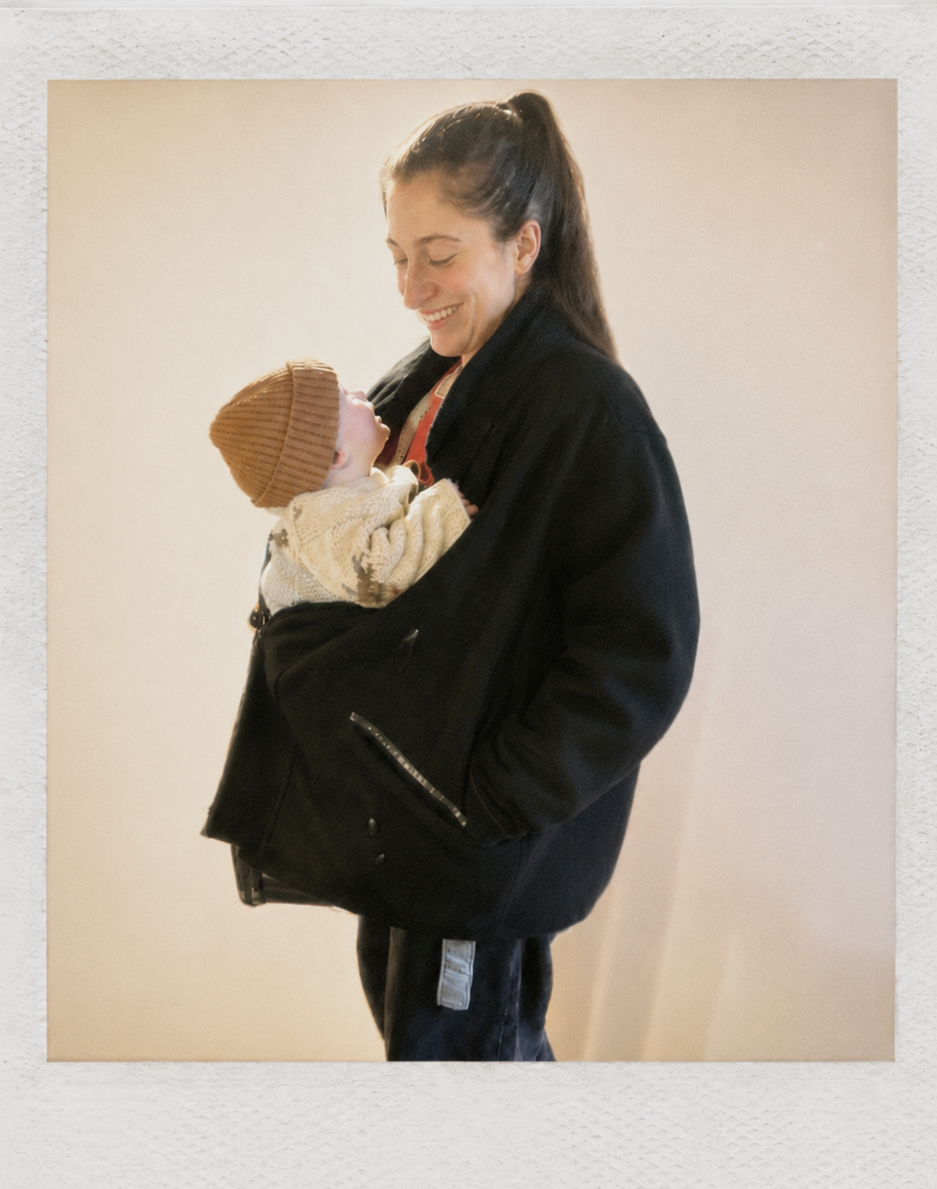 A woman holding a baby and smiling at the baby.