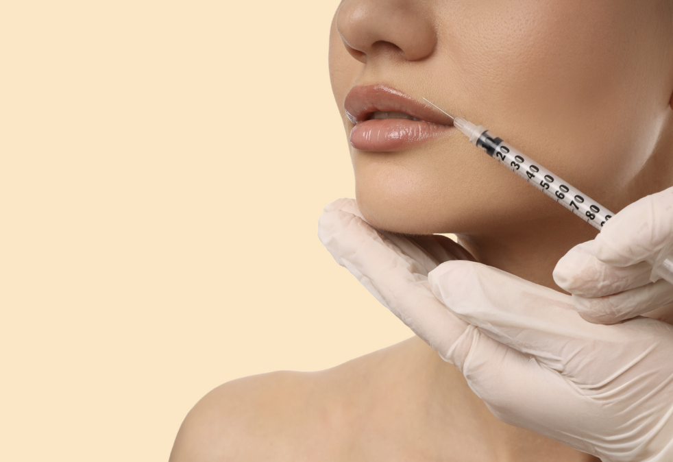 Close-up of a woman receiving a cosmetic injection in her lips, with a healthcare professional wearing gloves holding a syringe.