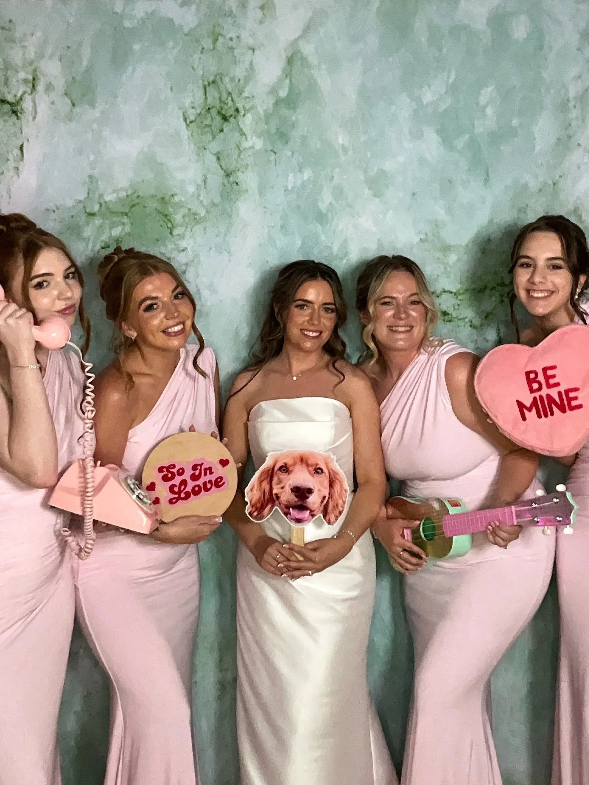 Friends posing with personalised props at a photo booth hire party in Cambridgeshire