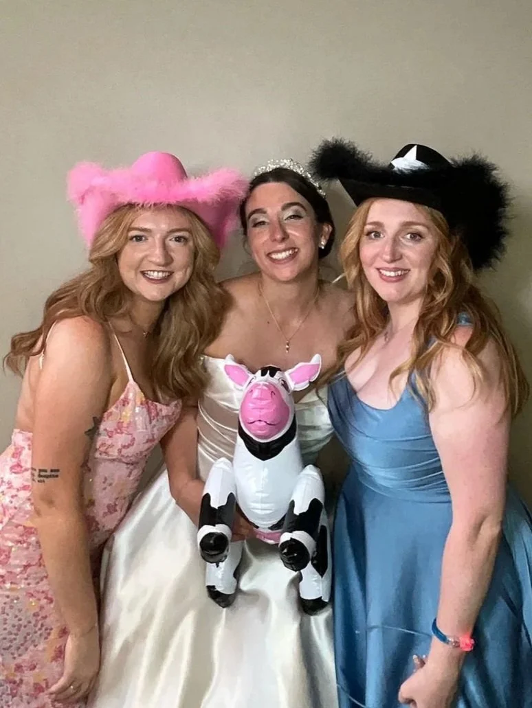 Friends posing with a cow balloon prop at a photo booth hire party in Spalding