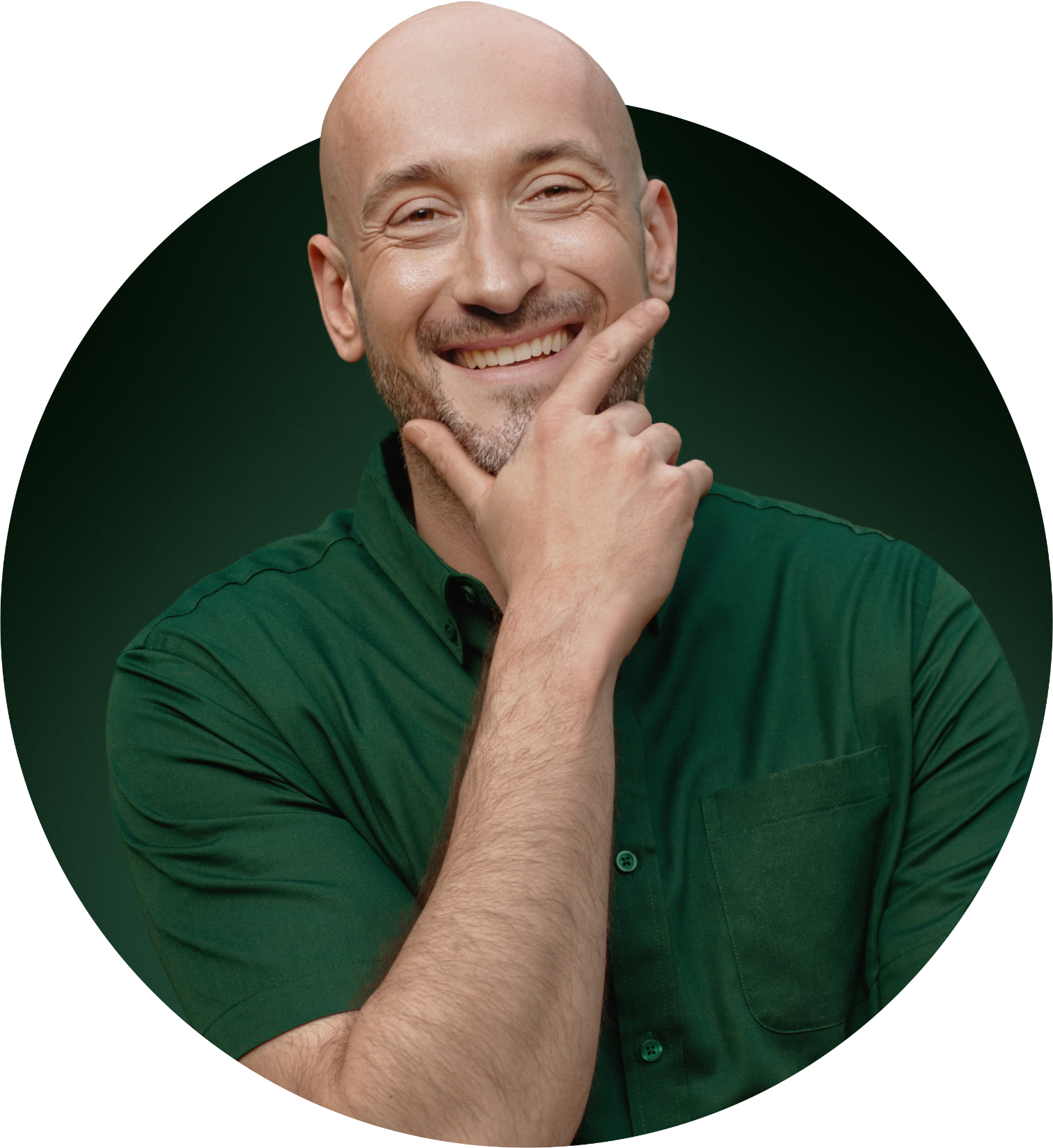 A smiling bald man with a beard, wearing a green shirt, with his hand resting on his chin, posing against a dark background.