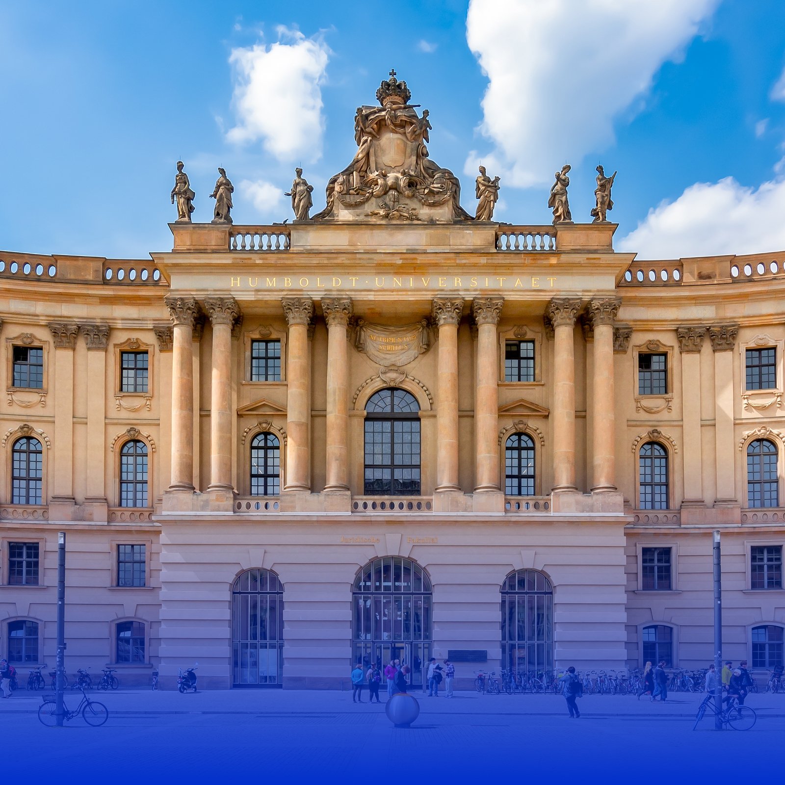 Facade of Humboldt University building with classical architecture, large windows, columns, and decorative statues on top, against a blue sky with clouds.