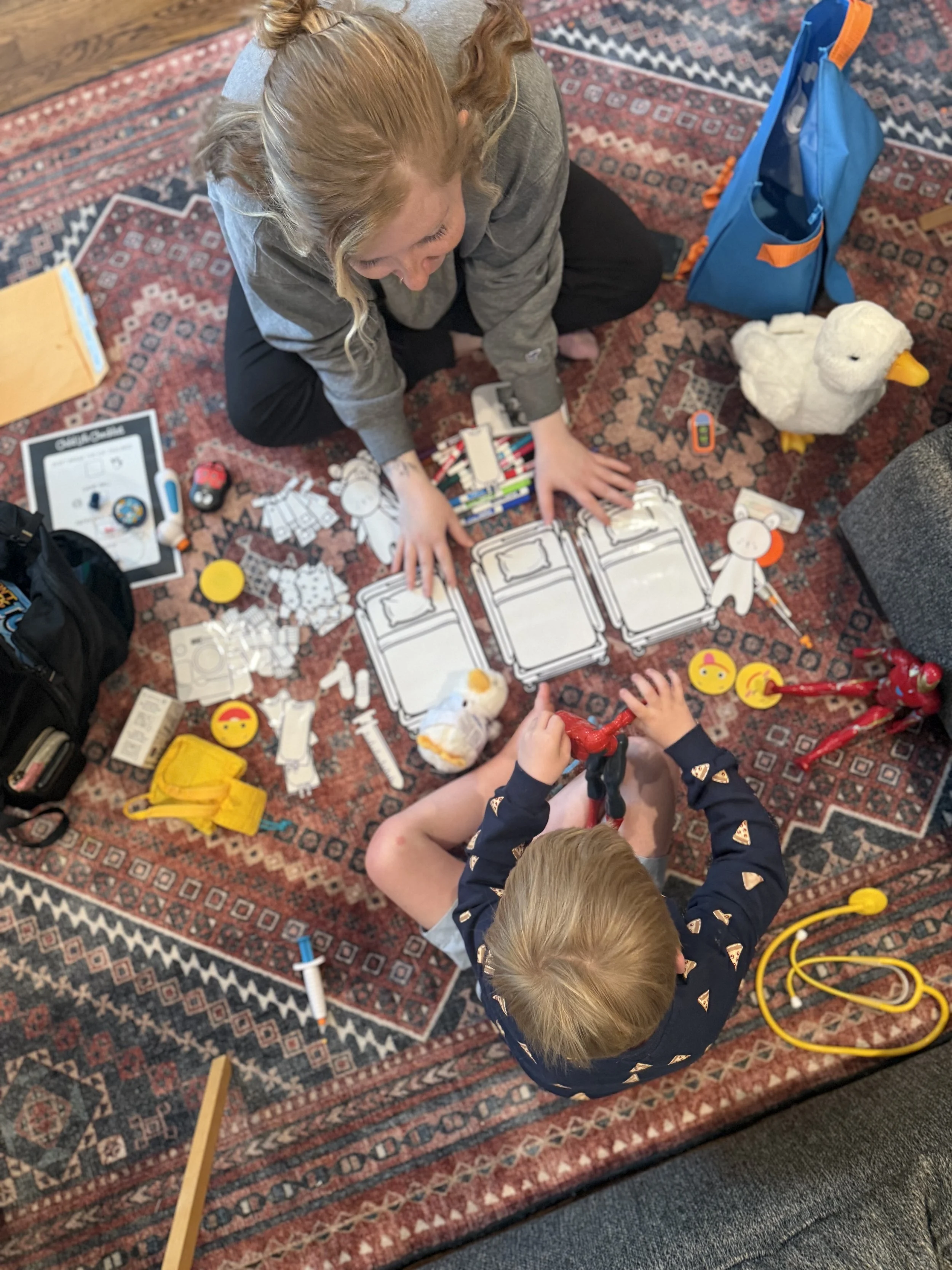 Children playing with educational toys and plush duck on a patterned rug, with a blue backpack nearby.