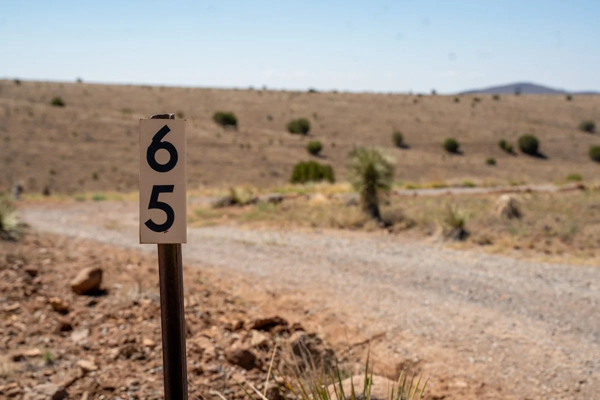A dirt road sign with the number 65 in Whiskey Creek Mobile Estates in Silver City, NM.
