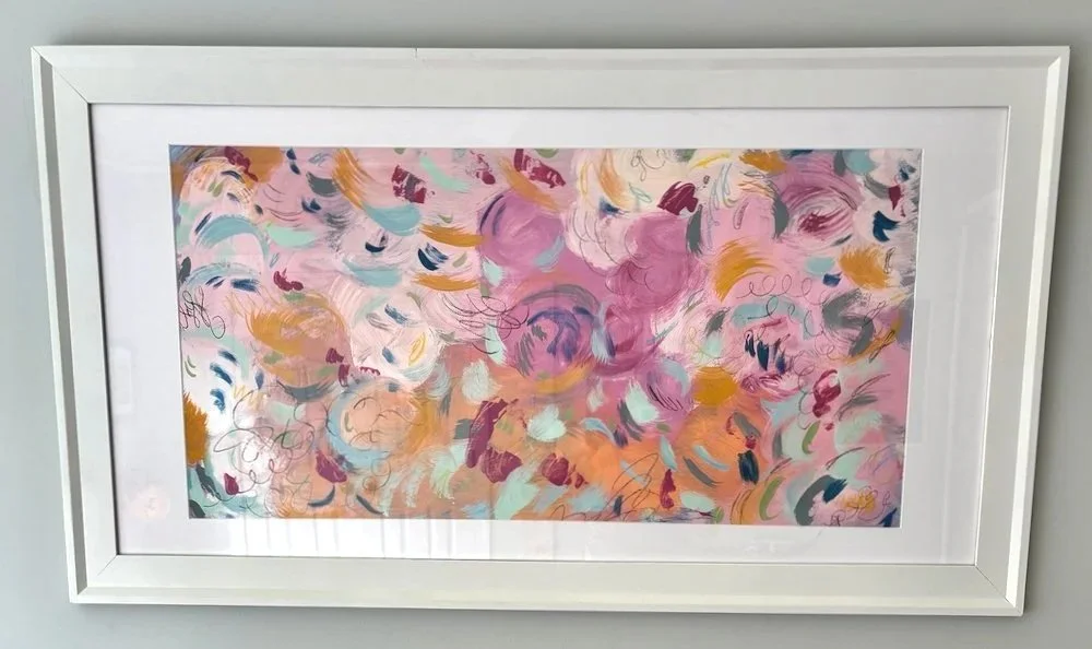 Abstract painting with pink, purple, orange, blue, green, and black brushstrokes and swirls in a white frame.