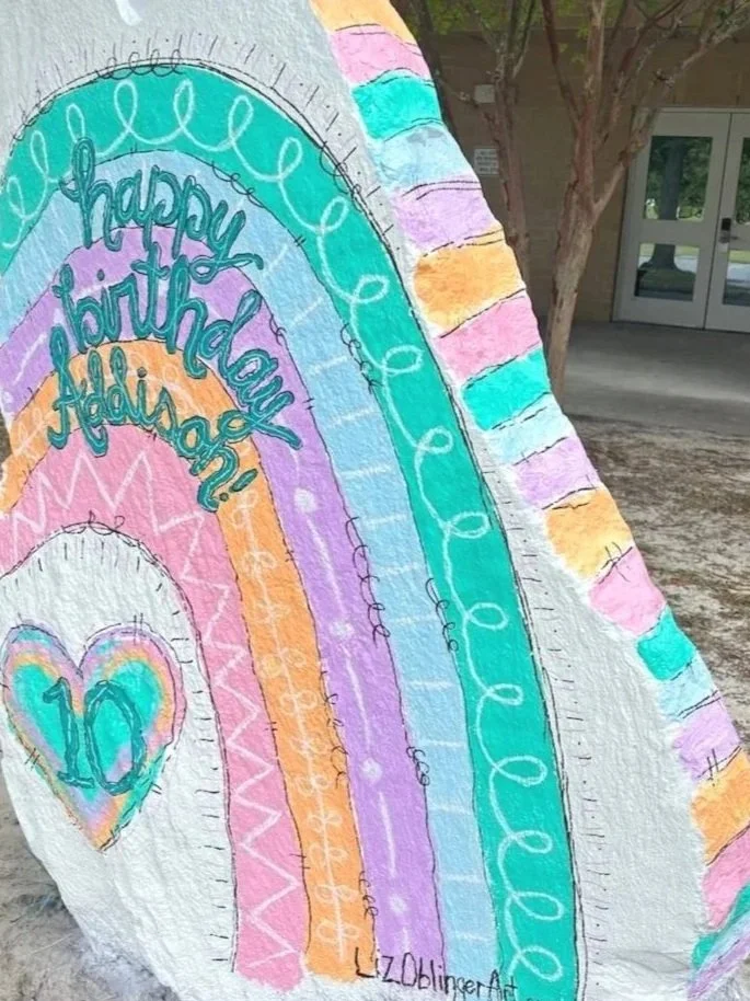 Colorful chalk art depicting a rainbow with the words 'happy birthday Addie!' and the number 10 inside a heart.