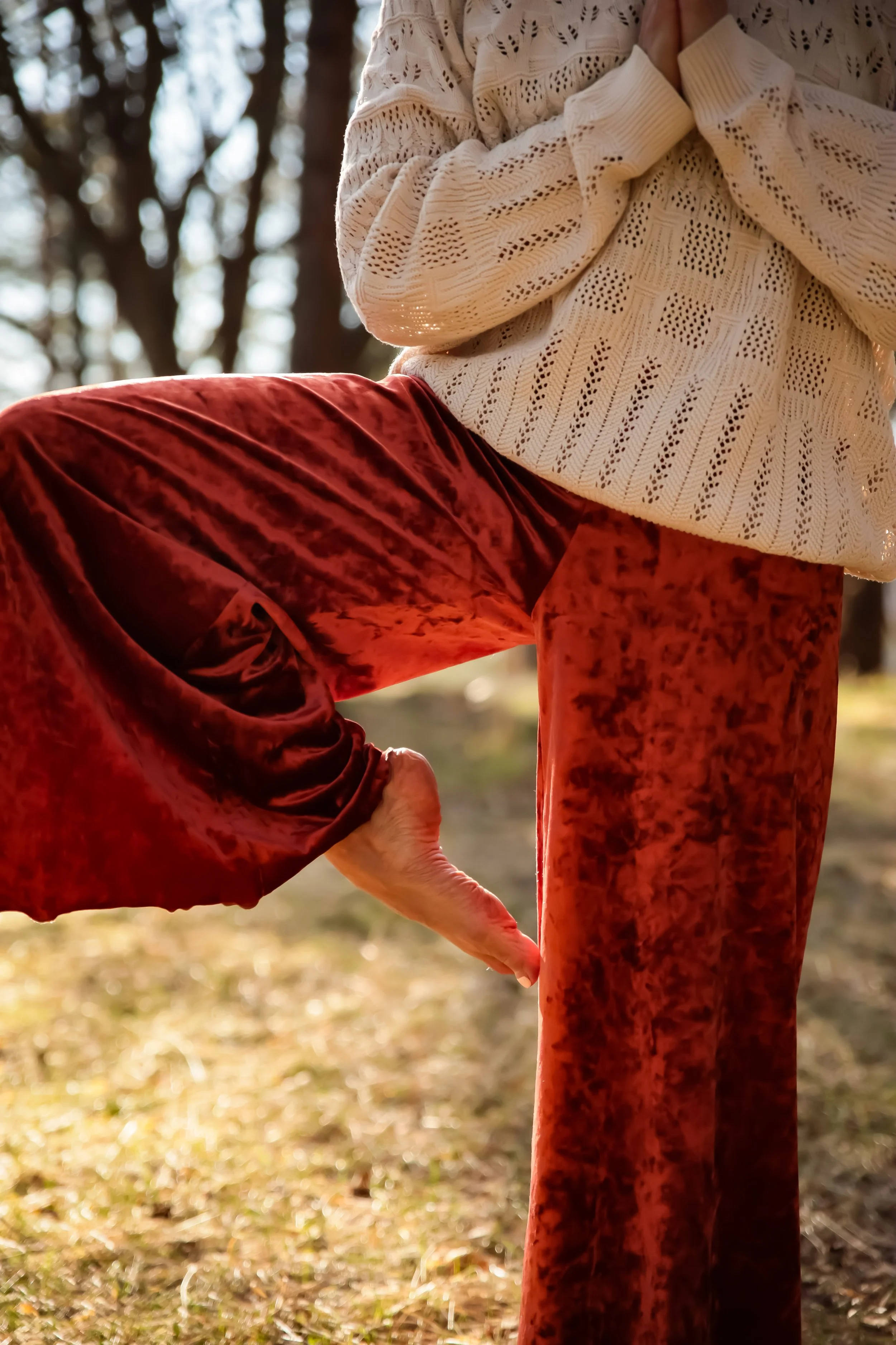 Joogaohjaaja Miila Rahomäki tekee yin ja yang -asennon luonnossa.
